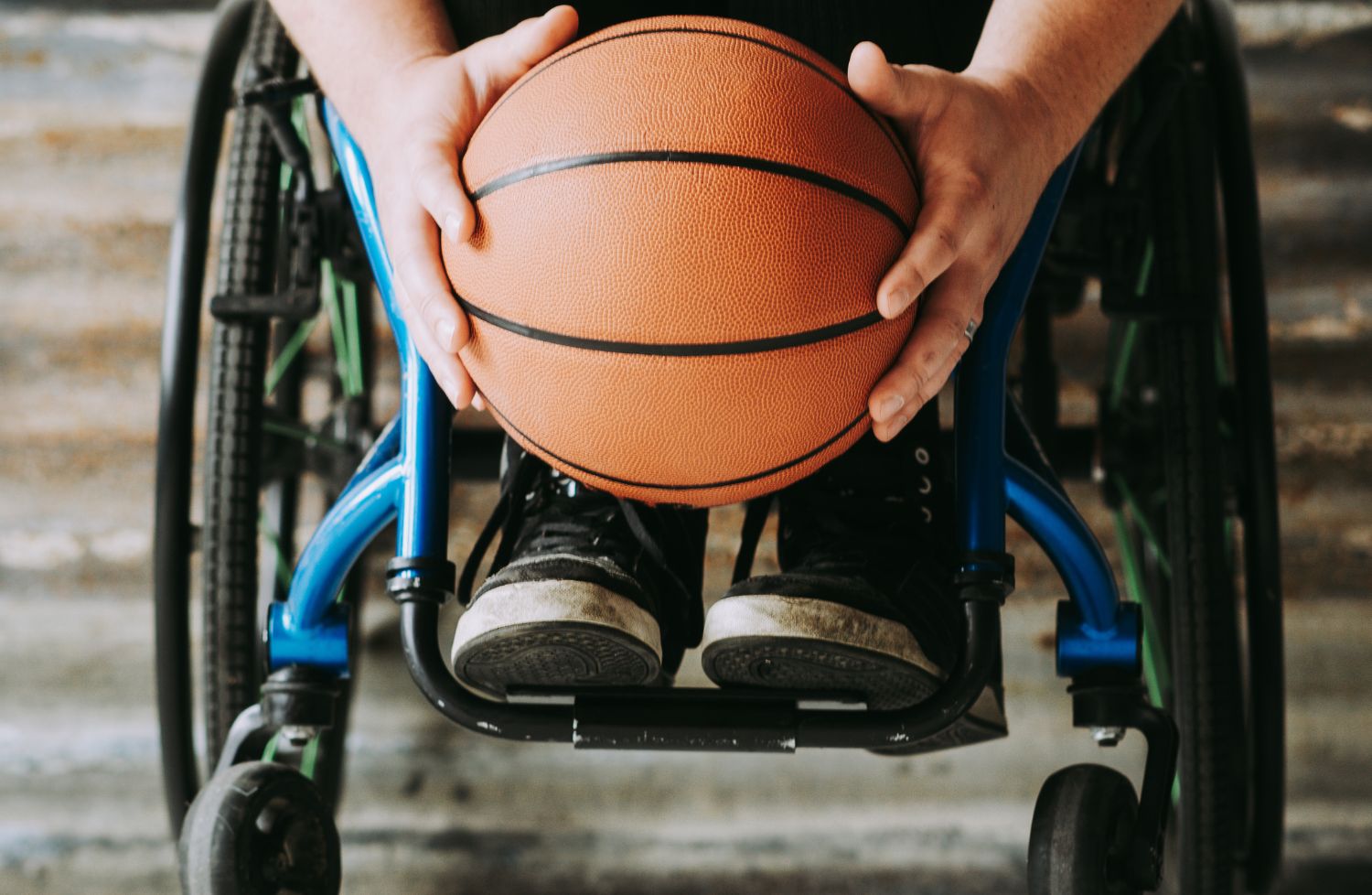 Persona su una carrozzina con una palla da basket in mano
