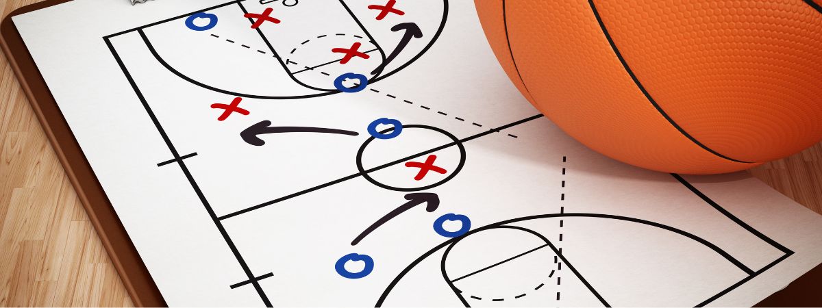 Foglio con schema tattico di basket e palla appoggiata sopra